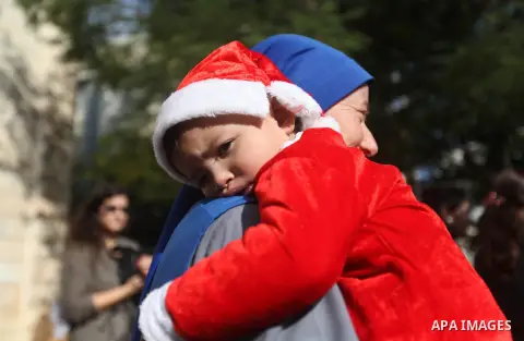 Palestinian child dressed as Pope Claus during visiting Latin Patriarch of Jerusalem Fouad Twal in Gaza City, Sunday, Dec. 16, 2012. Twal arrived in Gaza on Sunday to attend a celebration with Palestinians ahead of Chris...