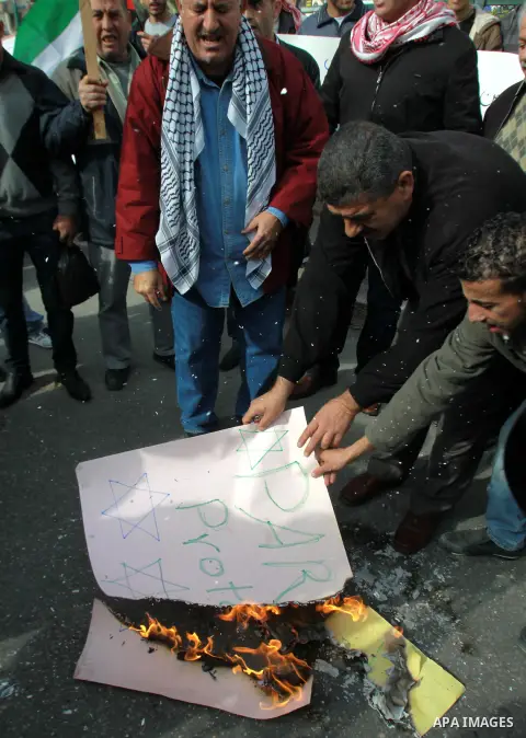 Palestinians burn a placard reading "Paris Protocol" and bearing the Star of David during a protest against the Paris Protocol and the Oslo Agreement, both key accords which govern economic ties between Palestinians and...