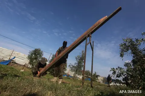Palestinian militants from al-Quds Brigades the armed wing of the Islamic Jihad organization, stand around a rocket launcher during military exercises at an undisclosed location in the Hamas-run Gaza Strip in Gaza city o...