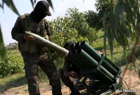 Palestinian militants from al-Quds Brigades the armed wing of the Islamic Jihad organization, stand around a rocket launcher during military exercises at an undisclosed location in the Hamas-run Gaza Strip in Gaza city o...