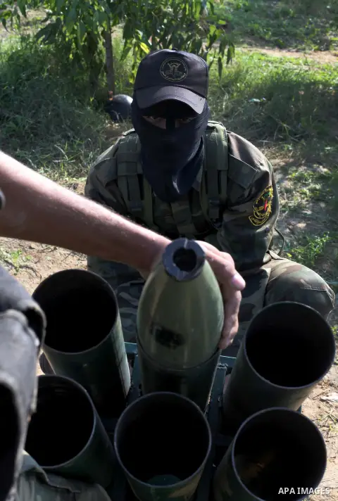 Palestinian militants from al-Quds Brigades the armed wing of the Islamic Jihad organization, stand around a rocket launcher during military exercises at an undisclosed location in the Hamas-run Gaza Strip in Gaza city o...