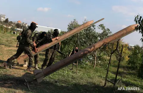 Palestinian militants from al-Quds Brigades the armed wing of the Islamic Jihad organization, stand around a rocket launcher during military exercises at an undisclosed location in the Hamas-run Gaza Strip in Gaza city o...