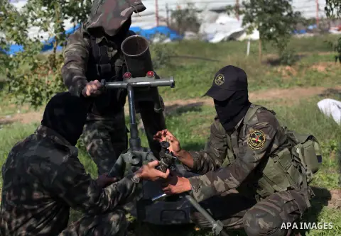 Palestinian militants from al-Quds Brigades the armed wing of the Islamic Jihad organization, stand around a rocket launcher during military exercises at an undisclosed location in the Hamas-run Gaza Strip in Gaza city o...