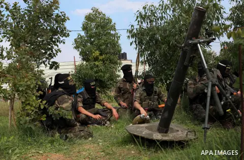 Palestinian militants from al-Quds Brigades the armed wing of the Islamic Jihad organization, stand around a rocket launcher during military exercises at an undisclosed location in the Hamas-run Gaza Strip in Gaza city o...