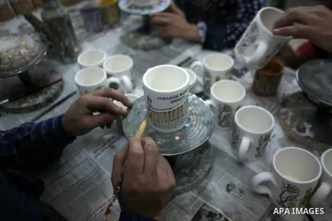Palestinian workesr paint on a ceramic cup by using traditional skills in the West Bank city of Hebron on 16 December, 2012. Palestinian ceramics are produced at traditional family-owned factories in Hebron and other cit...