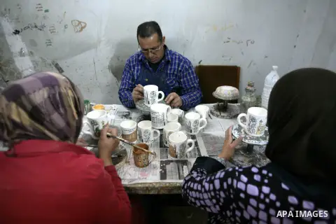 Palestinian workesr paint on a ceramic cup by using traditional skills in the West Bank city of Hebron on 16 December, 2012. Palestinian ceramics are produced at traditional family-owned factories in Hebron and other cit...