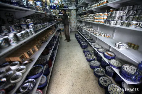 A Palestinian man looks at handicraft ceramic utensils in the West Bank city of Hebron on 16 December, 2012. Palestinian ceramics are produced at traditional family-owned factories in Hebron and other cities. Covering a...