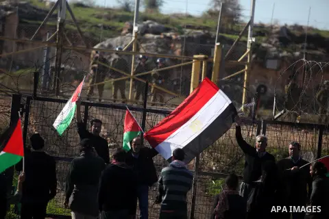Palestinian and foreign activists hold Palestinian and Egyptian national flags as they demonstrate in front of Israeli soldiers against the destruction of a monument commemorating the death of Egyptian soldiers killed du...