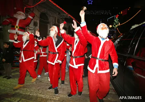 Palestinians dressed up as Santa Claus take part in a parade ahead of Christmas near Jerusalem's Old City December 16, 2012. Photo by Mahfouz Abu Turk