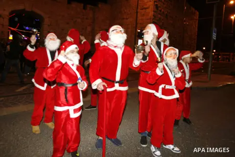 Palestinians dressed up as Santa Claus take part in a parade ahead of Christmas near Jerusalem's Old City December 16, 2012. Photo by Mahfouz Abu Turk