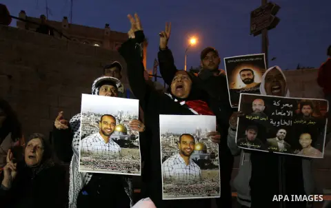 Palestinian protesters hold portraits of Samer Issawi, a Palestinian prisoner held in an Israeli jail and on a hunger strike since August 1, during a demonstration marking his birthday outside Damascus gate, in the old c...