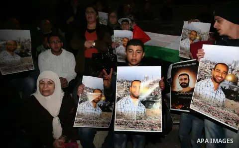 Palestinian protesters hold portraits of Samer Issawi, a Palestinian prisoner held in an Israeli jail and on a hunger strike since August 1, during a demonstration marking his birthday outside Damascus gate, in the old c...