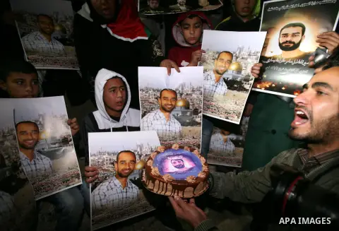 Palestinian protesters hold portraits of Samer Issawi, a Palestinian prisoner held in an Israeli jail and on a hunger strike since August 1, during a demonstration marking his birthday outside Damascus gate, in the old c...