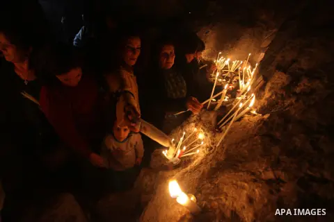 Palestinian Orthodox Christians light candles in a cave at the ancient monastery of St. Barbara, in the nearby hills close to the village of Abud, in the Israeli occupied West Bank, on December 16, 2012, as they celebrat...