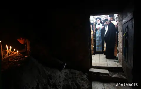 Palestinian Orthodox Christians light candles in a cave at the ancient monastery of St. Barbara, in the nearby hills close to the village of Abud, in the Israeli occupied West Bank, on December 16, 2012, as they celebrat...