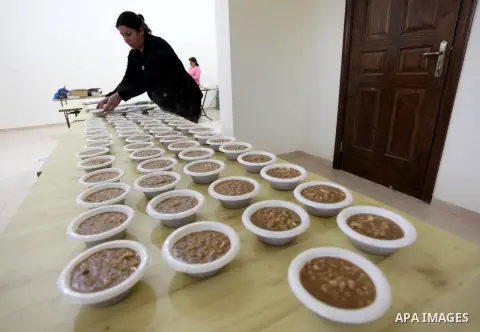 A Palestinian woman makes traditional sweets to mark the annual festival of St. Barbara's Day in the Palestinian village of Abud, in the Israeli occupied West Bank on December 16, 2012. Photo by Issam Rimawi