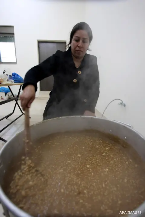 A Palestinian woman makes traditional sweets to mark the annual festival of St. Barbara's Day in the Palestinian village of Abud, in the Israeli occupied West Bank on December 16, 2012. Photo by Issam Rimawi