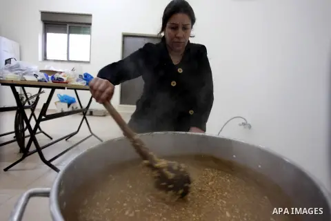 A Palestinian woman makes traditional sweets to mark the annual festival of St. Barbara's Day in the Palestinian village of Abud, in the Israeli occupied West Bank on December 16, 2012. Photo by Issam Rimawi