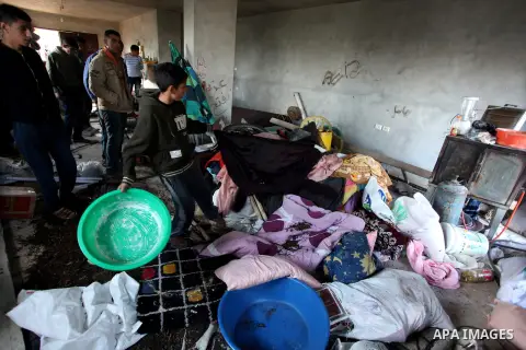 Palestinians look at ransacked belongings after Israeli soldiers entered the house and arrested three brothers and another Palestinian, who was wounded, in the northern West Bank village of Beit Rima, near Ramallah on De...