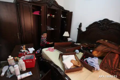 Palestinians look at ransacked belongings after Israeli soldiers entered the house and arrested three brothers and another Palestinian, who was wounded, in the northern West Bank village of Beit Rima, near Ramallah on De...