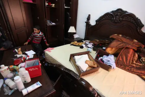 Palestinians look at ransacked belongings after Israeli soldiers entered the house and arrested three brothers and another Palestinian, who was wounded, in the northern West Bank village of Beit Rima, near Ramallah on De...