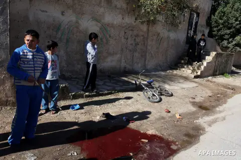 Palestinian children look at blood stains on the ground following a shooting attack in the northern West Bank town of Beit Rima, near Ramallah, on December 17, 2012. Photo by Issam Rimawi