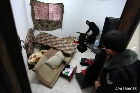 Palestinians look at ransacked belongings after Israeli soldiers entered the house and arrested three brothers and another Palestinian, who was wounded, in the northern West Bank village of Beit Rima, near Ramallah on De...
