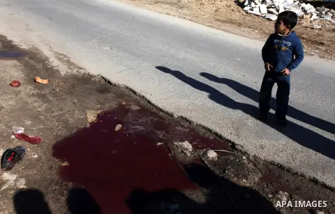 Palestinian children look at blood stains on the ground following a shooting attack in the northern West Bank town of Beit Rima, near Ramallah, on December 17, 2012. Photo by Issam Rimawi