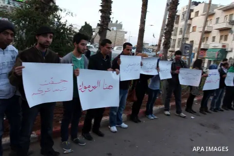 Palestinians hold placards during a protest in solidarity with Palestinian in al-Yarmouk refugee camp in Syria in the West Bank city of Ramallah on 17 December 2012. Pro-rebel sources reported that at least 25 Palestinia...