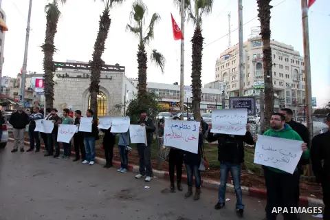 Palestinians hold placards during a protest in solidarity with Palestinian in al-Yarmouk refugee camp in Syria in the West Bank city of Ramallah on 17 December 2012. Pro-rebel sources reported that at least 25 Palestinia...