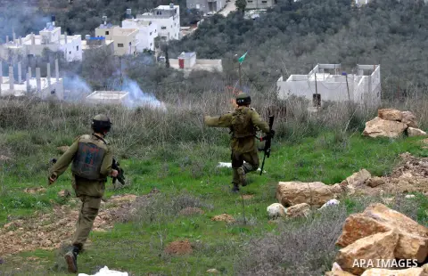 Israeli soldiers run during clashes between Jewish settlers and Palestinians, not seen, outside the West Bank village of Madama and the Jewish settlement of Yitzhar, near Nablus, Dec. 17, 2012. Photo by Nedal Eshtayah