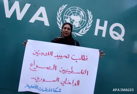 A Palestinian woman holds placards during a protest in solidarity with Palestinian in al-Yarmouk refugee camp in Syria in In front of the United Nations headquarters in Gaza City on 18 December 2012. Pro-rebel sources re...