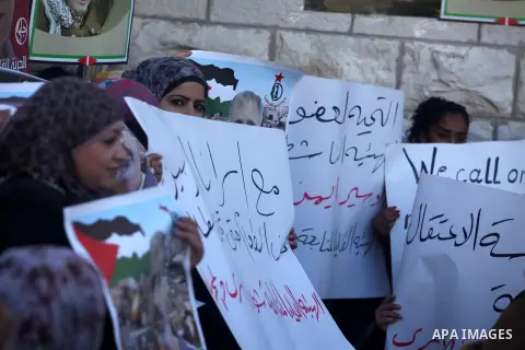 Palestinians hold pictures of prisoners held in Israeli jails during a sit-in outside the Red Crescent offices near the West Bank city of Ramallah on December 17, 2012. in solidarity with hunger-striking detainees held b...