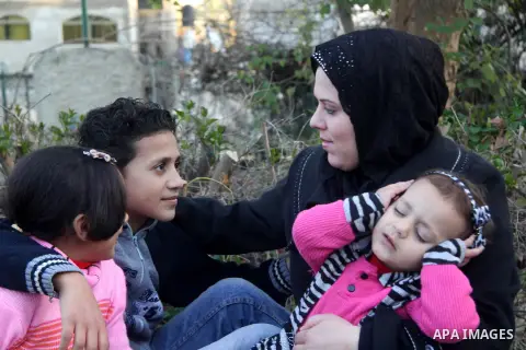 A Palestinian woman, Samar Bulbul plays with her kids at a park in Gaza city on Dec. 18,2012. Bulbul lost hearing after an Israeli airstrike targeted two Palestinian militants' car in Gaza city in December 2011. Photo by...