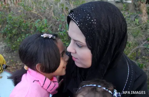 A Palestinian woman, Samar Bulbul plays with her kids at a park in Gaza city on Dec. 18,2012. Bulbul lost hearing after an Israeli airstrike targeted two Palestinian militants' car in Gaza city in December 2011. Photo by...