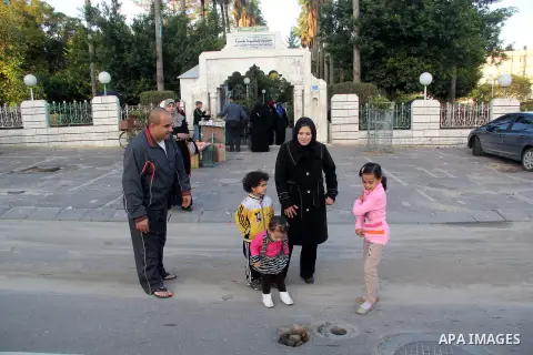 A Palestinian woman, Samar Bulbul walks with her family at a street in Gaza city on Dec. 18,2012. Bulbul lost hearing after an Israeli airstrike targeted two Palestinian militants' car in Gaza city in December 2011. Phot...