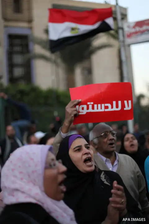 Egyptian protesters shout slogans against the President Mohamed Morsi and hold a banner reading in Arabic 'no to the constitution' during a demonstration against the draft constitution, in Cairo, Egypt, 18 December 2012....