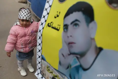 Palestinians hold pictures of prisoners held in the Israeli jails during a rally in Gaza city on December 19, 2012. in solidarity with hunger-striking detainees held by Israel to demand their release from detention witho...