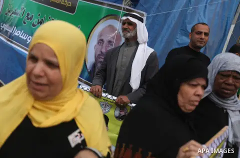 Palestinians hold pictures of prisoners held in the Israeli jails during a rally in Gaza city on December 19, 2012. in solidarity with hunger-striking detainees held by Israel to demand their release from detention witho...