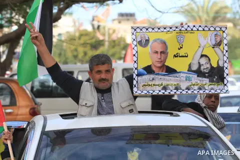 Palestinians hold pictures of prisoners held in the Israeli jails during a rally in Gaza city on December 19, 2012. in solidarity with hunger-striking detainees held by Israel to demand their release from detention witho...