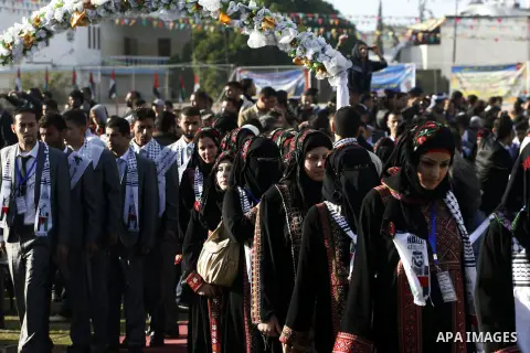 Palestinian brides and grooms pose during a mass wedding ceremony in Rafah southern Gaza strip, on December 19, 2012. The mass wedding organized by National Islamic Committee and funding by the institution of Sheikh Khal...