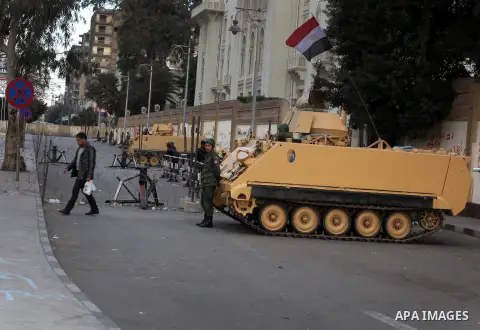 Egyptian army soldiers and tanks stand behind barbed wire as hundreds of opposition protesters arrive at the Presidential Palace in Cairo on December 19, 2012 during a demonstration against President Mohammed Morsi and t...