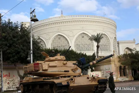 Egyptian army soldiers and tanks stand behind barbed wire as hundreds of opposition protesters arrive at the Presidential Palace in Cairo on December 19, 2012 during a demonstration against President Mohammed Morsi and t...