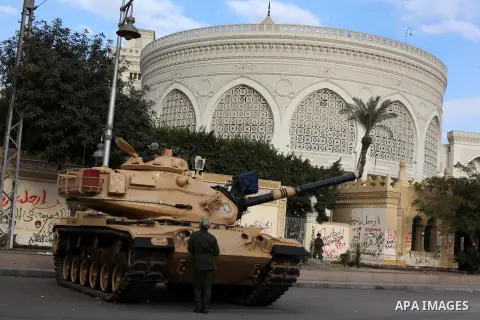 Egyptian army soldiers and tanks stand behind barbed wire as hundreds of opposition protesters arrive at the Presidential Palace in Cairo on December 19, 2012 during a demonstration against President Mohammed Morsi and t...