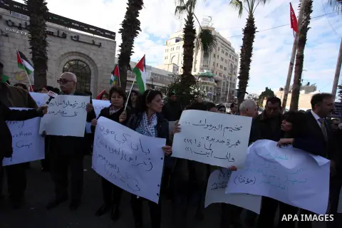 Palestinians hold placards during a protest in solidarity with Palestinian in al-Yarmouk refugee camp in Syria in the West Bank city of Ramallah on 19 December 2012. Pro-rebel sources reported that at least 25 Palestinia...