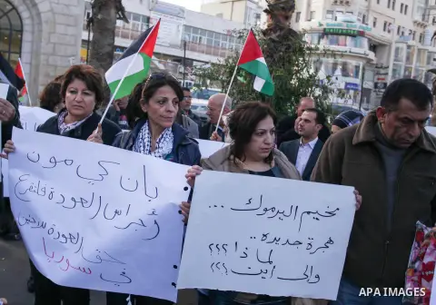 Palestinians hold placards during a protest in solidarity with Palestinian in al-Yarmouk refugee camp in Syria in the West Bank city of Ramallah on 19 December 2012. Pro-rebel sources reported that at least 25 Palestinia...