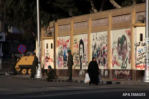 Egyptians walk pass the wire barricade as Egyptian army soldiers and tanks guard the presidental palace in Cairo December 19, 2012. Opponents of Egyptian President Mohamed Mursi staged protests in Cairo on Tuesday agains...