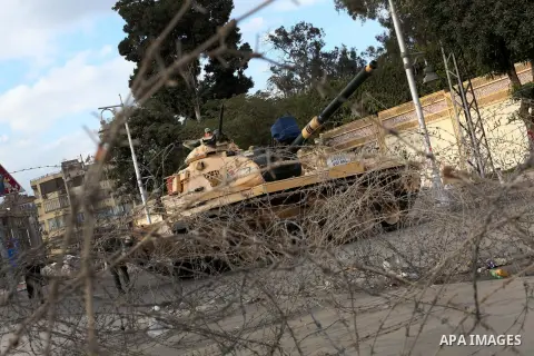 Egyptian army soldiers and tanks stand behind barbed wire as hundreds of opposition protesters arrive at the Presidential Palace in Cairo on December 19, 2012 during a demonstration against President Mohammed Morsi and t...