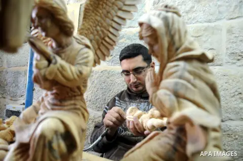 A Palestinian carpenter carves a wooden sculpture of baby Jesus at a workshop in the West Bank town of Bethlehem, on December 20, 2012. The traditional birthplace of Jesus Christ prepares to celebrate Christmas later thi...