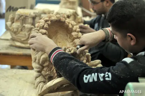 A Palestinian carpenter carves a wooden sculpture of baby Jesus at a workshop in the West Bank town of Bethlehem, on December 20, 2012. The traditional birthplace of Jesus Christ prepares to celebrate Christmas later thi...